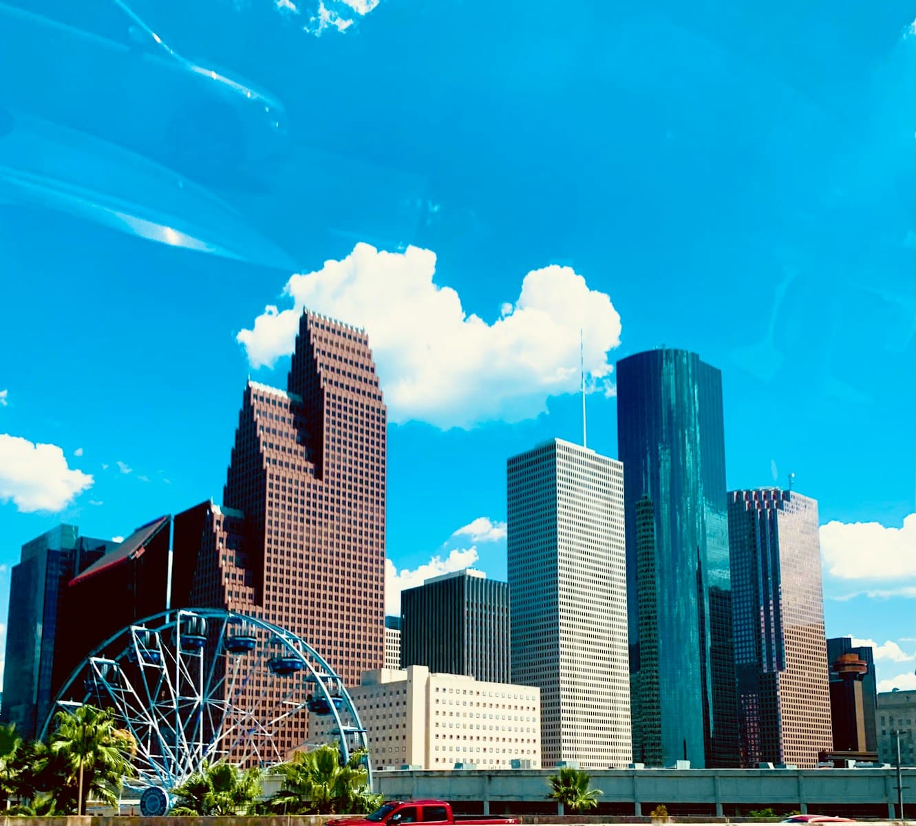 a city skyline with a ferris wheel in the foreground